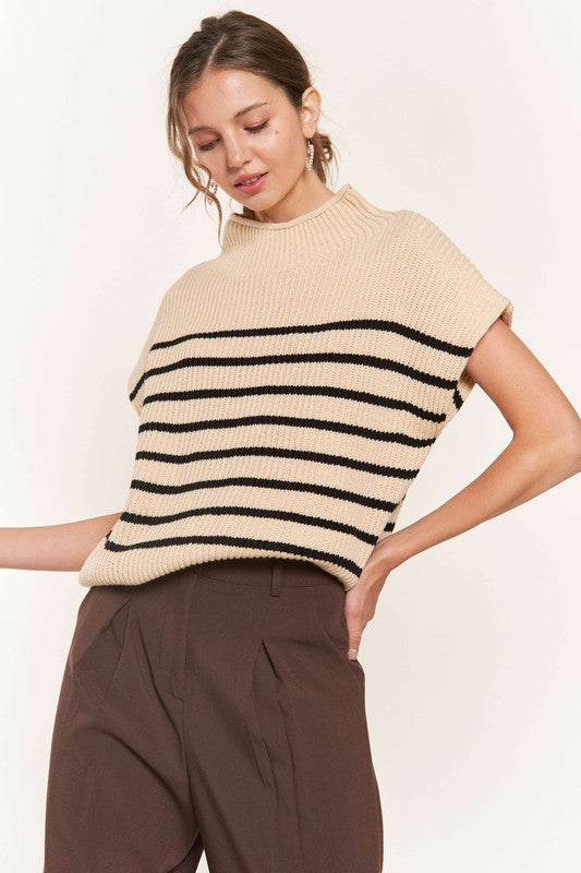 A woman modeling a beige striped sweater vest