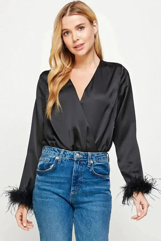 A model showcasing a black satin bodysuit with feather trim sleeve detail for women