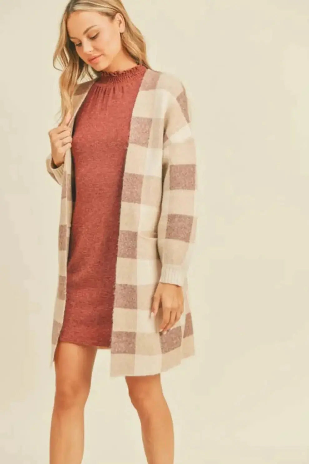 A woman modeling a ginger and cream plaid open cardigan
