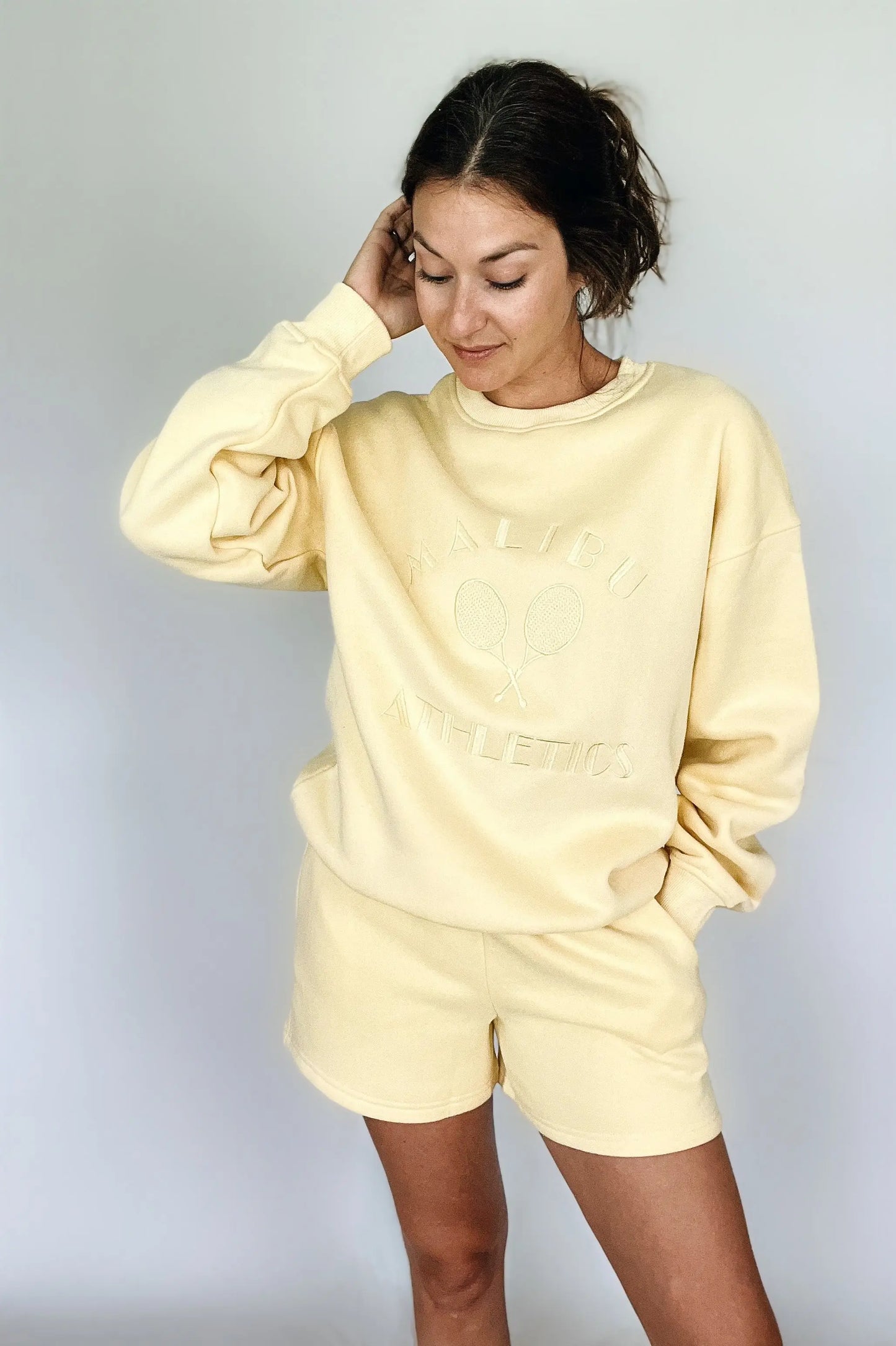 The Tiny Details modeling the Malibu Athletics Yellow Pullover Sweatshirt