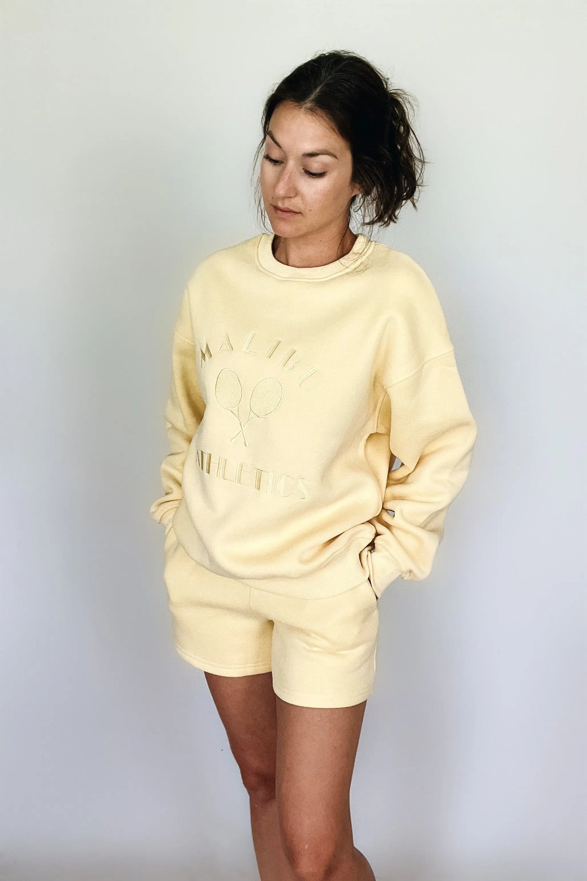 The Tiny Details modeling the Malibu Athletics Yellow Pullover Sweatshirt