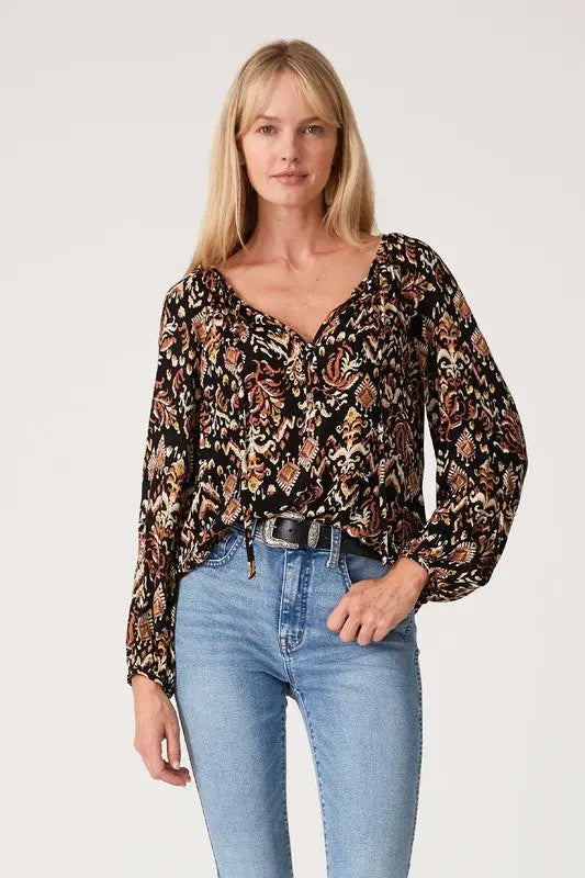 A woman modeling the printed long sleeve tie neck blouse