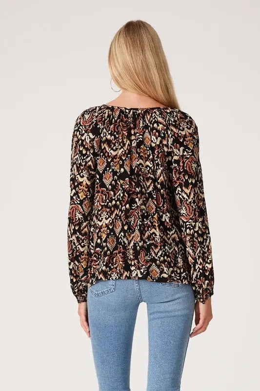 A woman modeling the printed long sleeve tie neck blouse