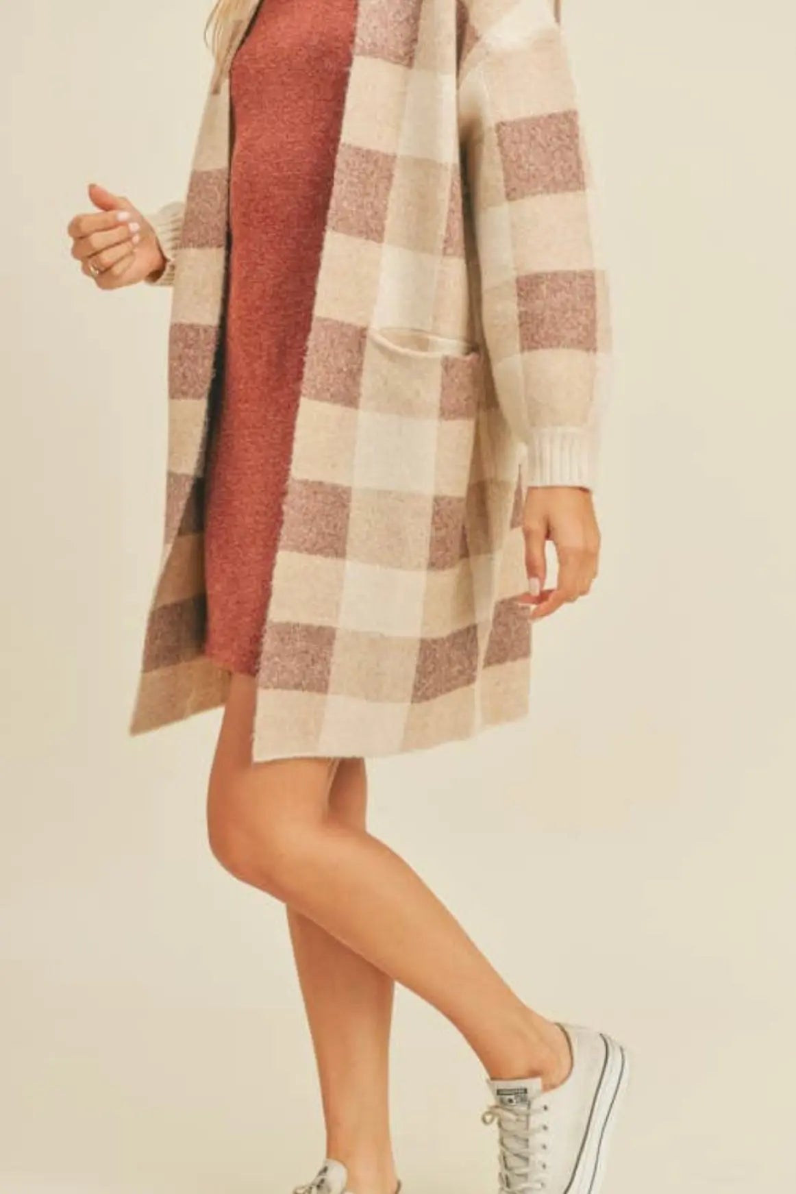 A woman modeling a ginger and cream plaid open cardigan