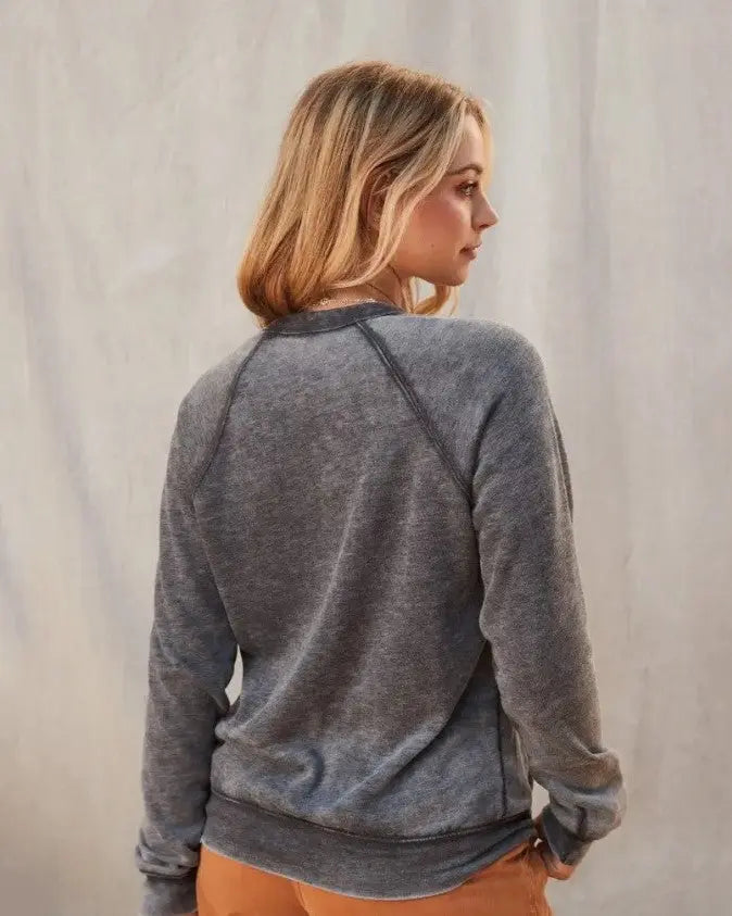 A women modeling the touchdown graphic fleece acid wash pullover